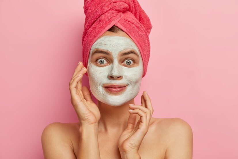 photo-jeune-femme-attaractive-applique-masque-nutritif-pour-soins-du-visage-veut-avoir-peau-fraiche-propre-porte-serviette-rose-tete_273609-30724